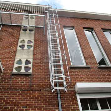 Drop-down ladder with safety cage and used to link a balcony to the ground floor.
