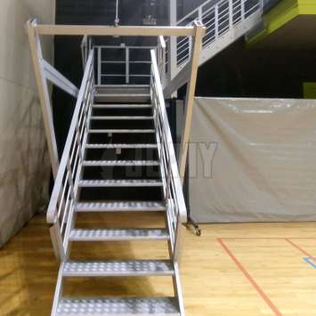 Retractable stairs with cable and pulley system in a gym.